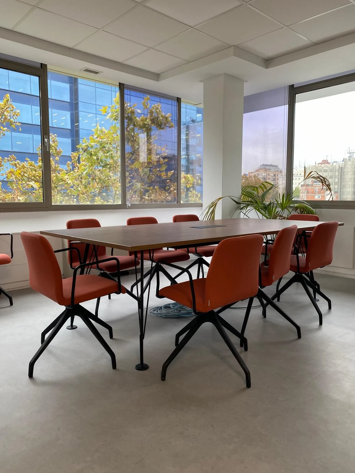 Sala de reuniones en oficina con grandes ventanales y mobiliario moderno