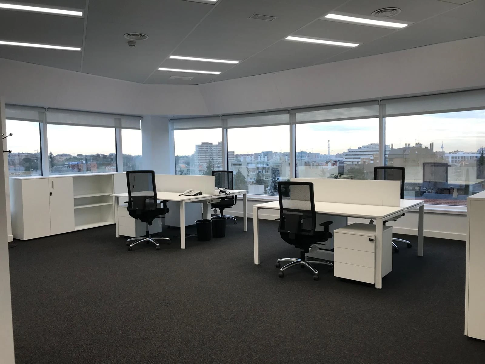 Oficina moderna con grandes ventanales con luz natural